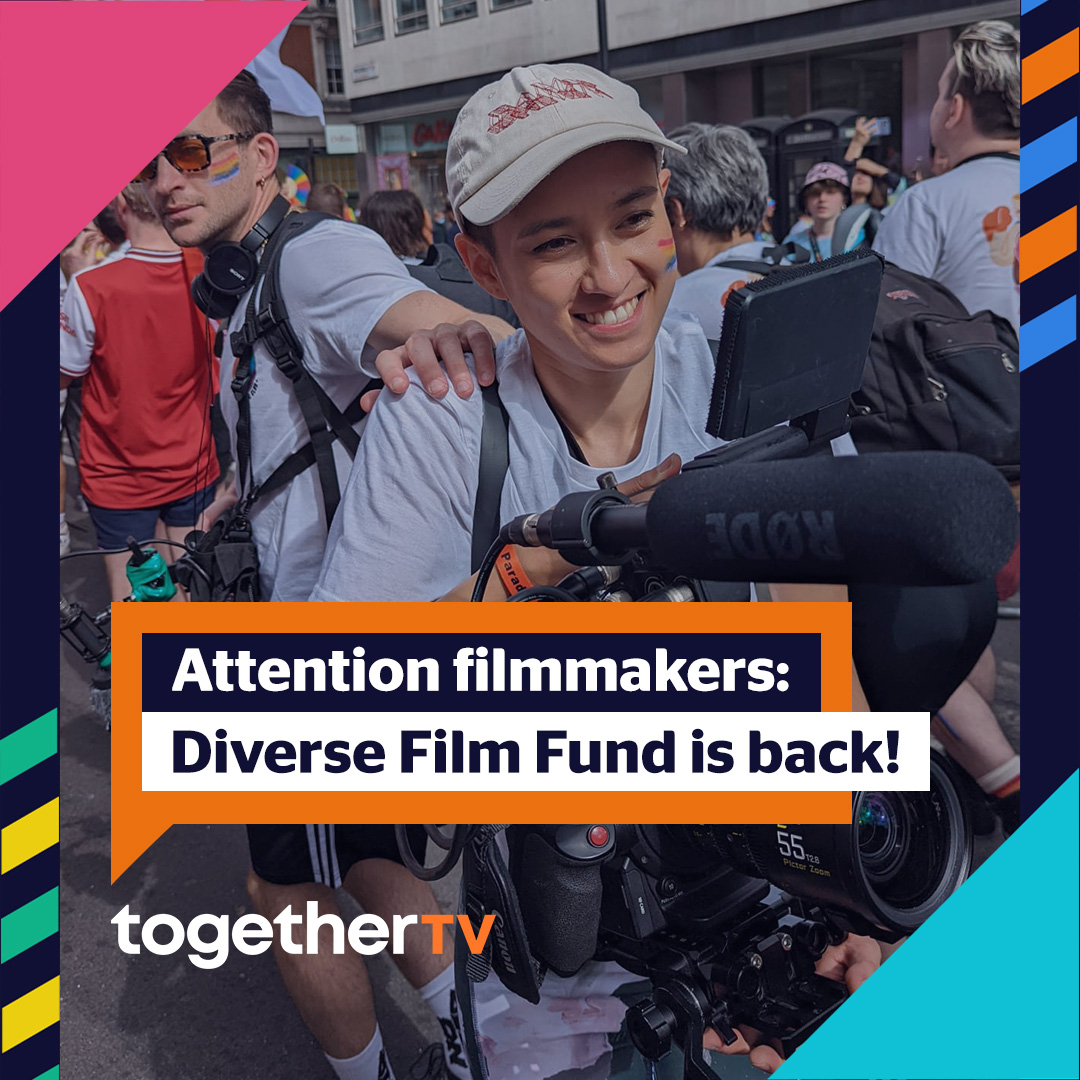 A tan person wearing a beige hat with red writing on it, a grey shirt, with rainbow stripes on their face, holding a big camcorder with a rode mic, smiling, in a group of other people walking the opposite way down the street wearing the same shirts. Text that appears on the photo reads: Attention filmmakers: Diverse Film Fund is back! in an orange speech bubble with a logo reading together TV underneath it.