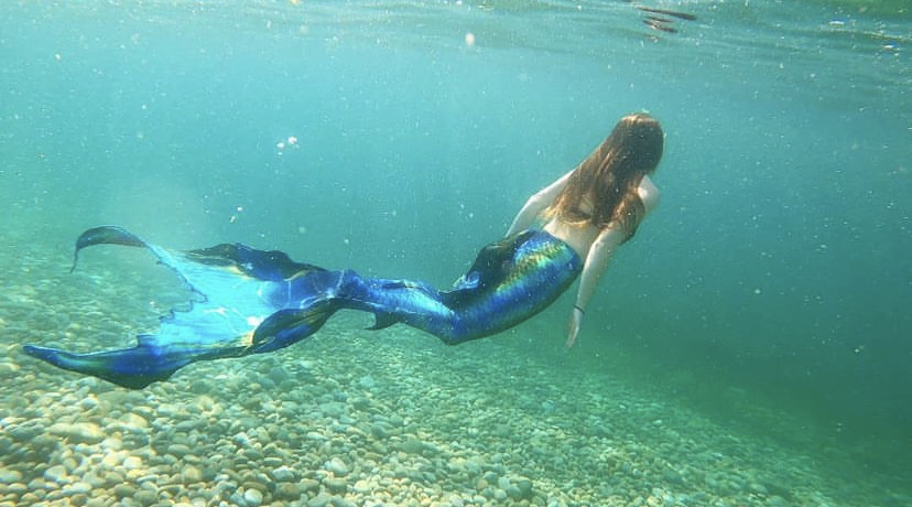 Mermaid swimming underwater with a blue fin from "Mermaids Really Do Exist".